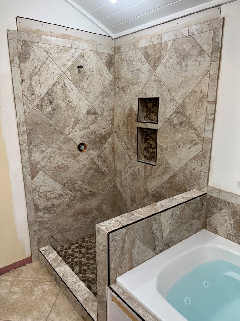 unique tile shower with a tub next to it